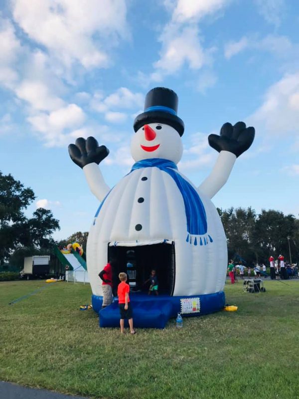 A large Snow Man Bounce House in a park.