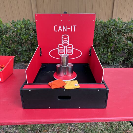 A red table with a Can Smash Game on it.
