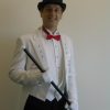 A man in a white tuxedo holding a cane delivers a Singing Telegram.