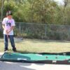 Two boys playing a game of Mini Golf.