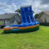 A colossal Storm Surge Slide (22') towering in front of a house, providing endless aquatic thrills for all ages.