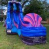 A blue and purple Mermaid Slide in a grassy area.