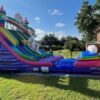 A large Unicorn Slide in the backyard of a house.