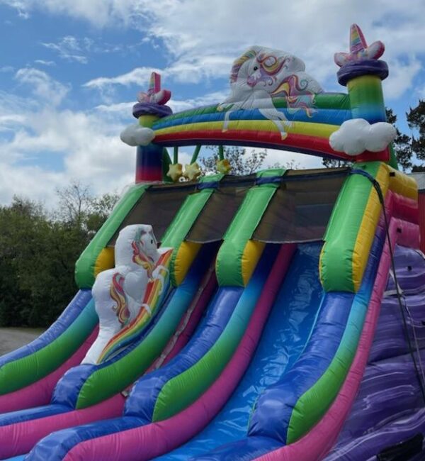 A colorful inflatable slide with a unicorn on it.