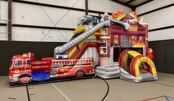 A Fire Truck Bounce House and Slide Combo in a gymnasium.